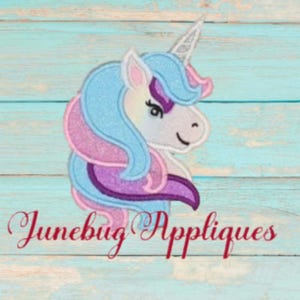 May include: Embroidered design of a unicorn's head with a blue, pink, and purple mane. The unicorn has a white face with a closed eye and a pink nose. The design is perfect for creating personalized items like shirts, bags, or home decor.