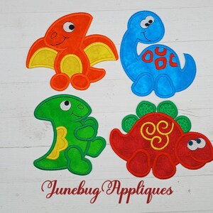 May include: Four felt applique dinosaur designs. A green dinosaur, a red dinosaur, an orange dinosaur, and a blue dinosaur.