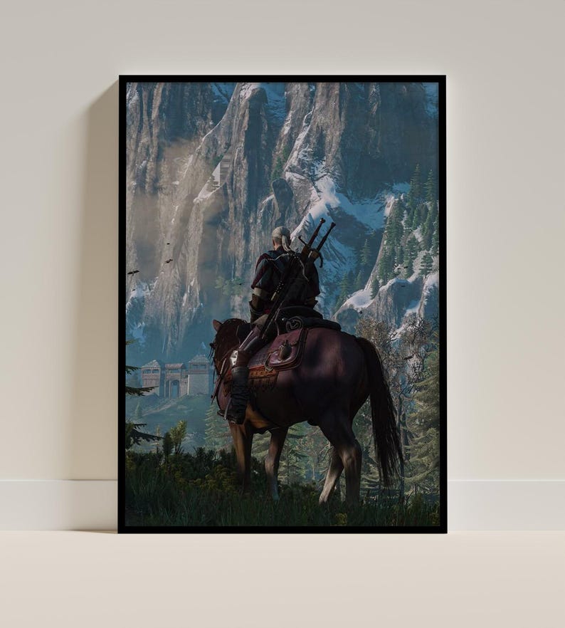 May include: A framed vertical wall art print depicting a white-haired figure in dark armor riding a brown horse. The rider carries two swords on their back, facing a massive, snow-capped mountain range with a stone fortress visible in the distance.