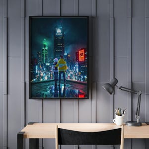 May include: A framed art print depicts a couple overlooking a futuristic cityscape at night. The scene is illuminated by neon lights and rain. The couple is wearing a yellow jacket and a white jacket. The artwork is displayed on a gray wall above a wooden desk.
