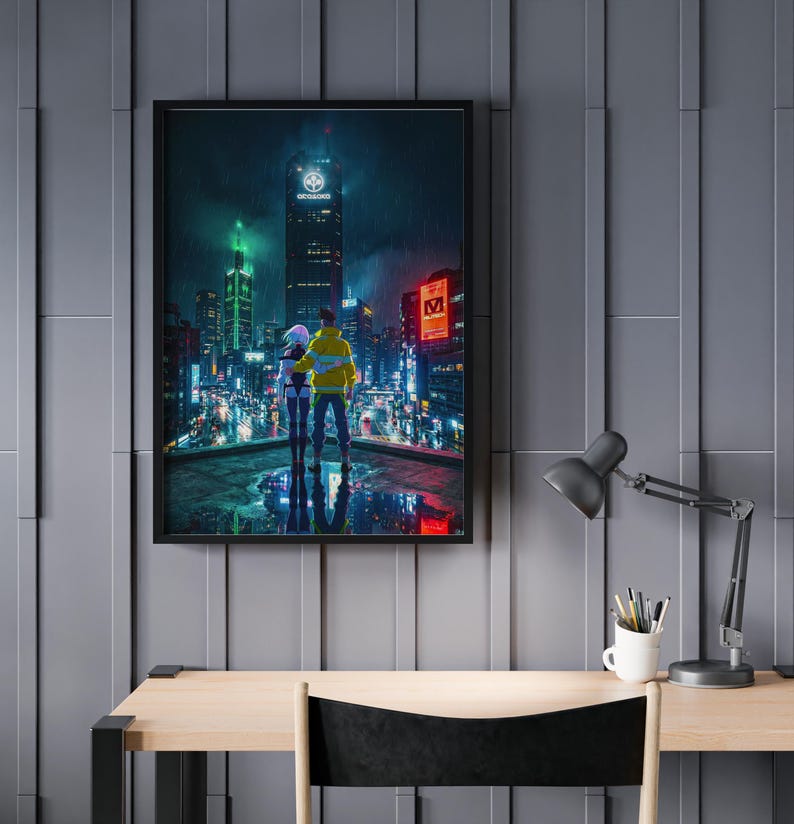 May include: A framed art print depicts a couple overlooking a futuristic cityscape at night. The scene is illuminated by neon lights and rain. The couple is wearing a yellow jacket and a white jacket. The artwork is displayed on a gray wall above a wooden desk.