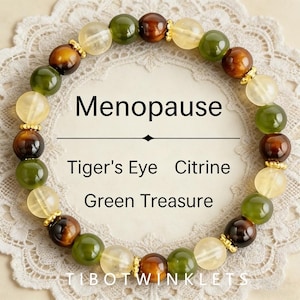 May include: A circular beaded bracelet featuring alternating round beads of brown Tiger's Eye, translucent yellow Citrine, and opaque green stone, accented with small gold-toned metal spacers. The text Menopause, Tiger's Eye, Citrine, Green Treasure, and TIBOTWINKLETS is visible.