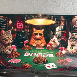 May include: A rectangular wall art print depicting five cats playing poker at a green table. The text reads PAWS, NOT CLAWS, FEED ME LUCKY, HOUSE RULES, and KITTY HOLD'EM. The cats are sitting around piles of kibble and playing cards.