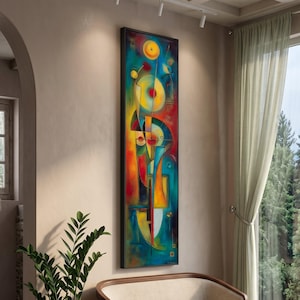 Könnte beinhalten: Abstrakte Kunstmalerei in einem vertikalen schwarzen Rahmen. Das Kunstwerk zeigt eine lebendige Mischung aus Farben, darunter Rot, Gelb, Blau und Grün. Geometrische Formen bilden eine einzigartige Komposition. Das Gemälde wird an einer beigen Wand ausgestellt.