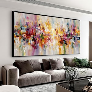 Puede incluir: Una gran pieza de arte mural rectangular que presenta una pintura al óleo abstracta con pinceladas gruesas y texturizadas en tonos vibrantes de amarillo, naranja, rojo, morado y azul, sobre un fondo claro y neutro en un marco negro.