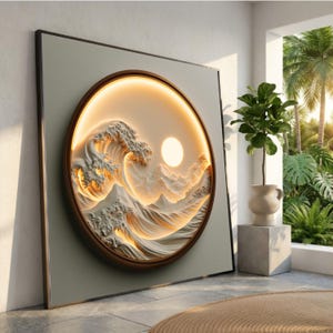 Op de afbeelding: Een vierkant wandkunstwerk met een cirkelvormig frame en een warme, verlichte reliëfsculptuur van een gestileerde oceaangolf en een zon. Het kunstwerk is geplaatst tegen een lichtgrijze achtergrond en toont gedetailleerde texturen.