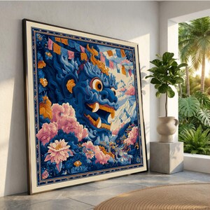 Pode incluir: Uma impressão de arte emoldurada com uma ilustração vibrante de uma criatura mítica azul com a boca aberta, em um cenário de montanhas, flores e bandeiras de oração. A obra de arte é emoldurada em um tom neutro, encostada em uma parede.