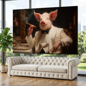 Op de afbeelding: Een ingelijste canvas print toont een varken in een wit pak en een vlinderdas, dat een sigaar rookt. Het varken zit aan een tafel met een wit tafelkleed, tegen een donkere achtergrond. De print wordt weergegeven boven een crèmekleurige, gecapitonneerde bank.