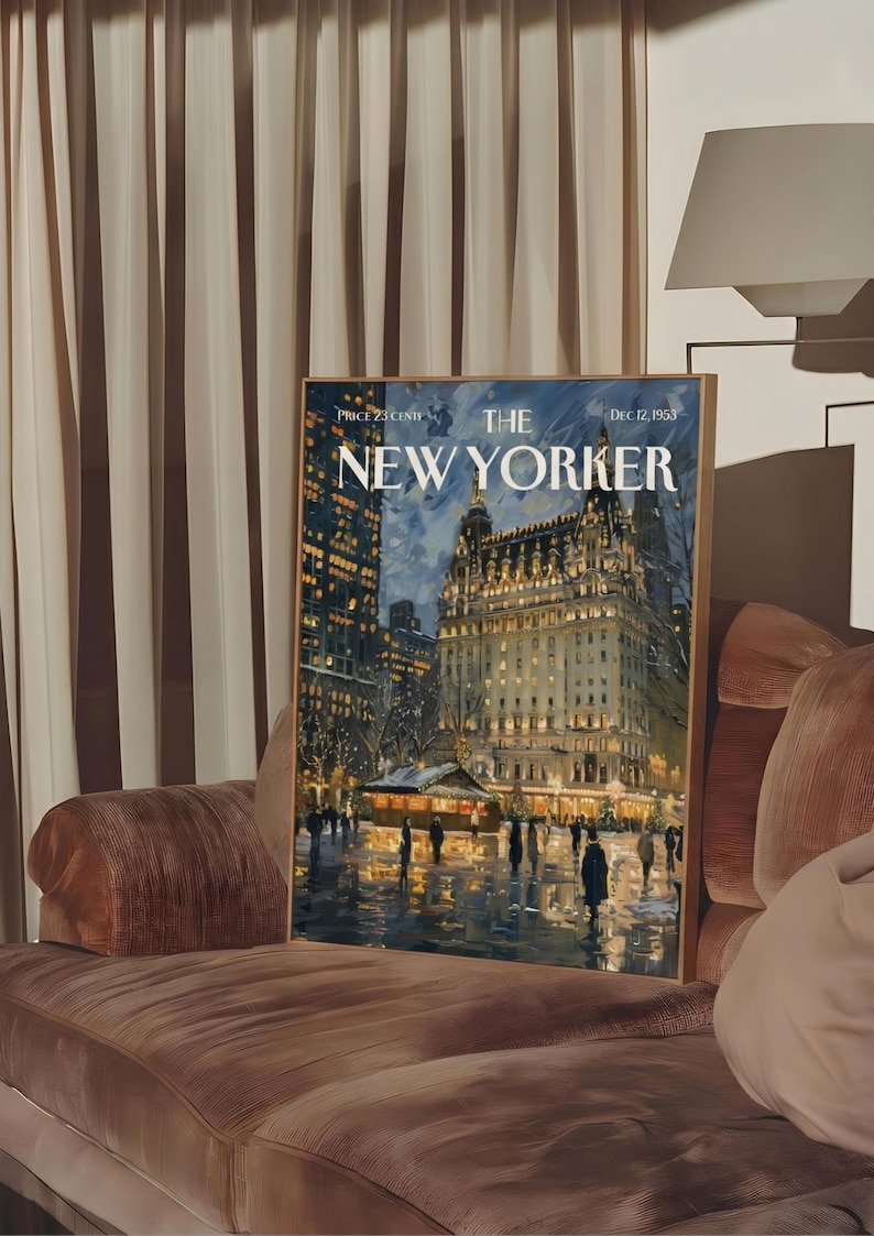 May include: A framed print of a New Yorker magazine cover from December 12, 1953, featuring a nighttime cityscape with a large building and figures. The print is displayed on a brown velvet sofa.