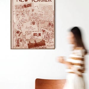 May include: A framed vintage New Yorker magazine cover from September 17, 1966, with a sepia-toned illustration of letters and stamps. The magazine cover is displayed on a white wall, with a blurred figure in the background.
