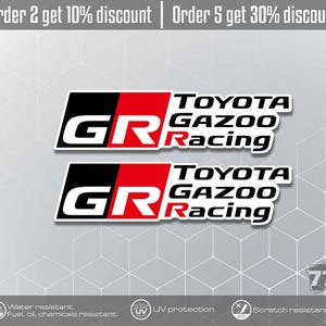 Puede incluir: Dos pegatinas de vinilo rectangulares con el logotipo de Toyota Gazoo Racing. Cada pegatina muestra un fondo negro y rojo con las letras blancas GR y el texto Toyota Gazoo Racing en negro. Las pegatinas son resistentes al agua, aceite y productos químicos.