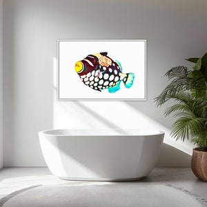 May include: A framed wall art print featuring a clown triggerfish with a white body, large black spots, a yellow mouth, and orange-patterned dorsal area. The fish is depicted in a vibrant, colorful style against a stark white background.