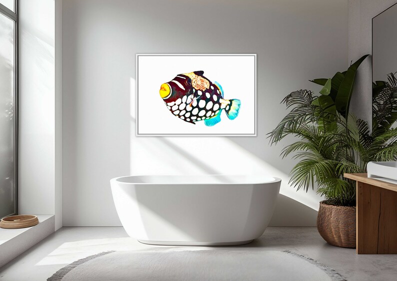 May include: A framed wall art print featuring a clown triggerfish with a white body, large black spots, a yellow mouth, and orange-patterned dorsal area. The fish is depicted in a vibrant, colorful style against a stark white background.