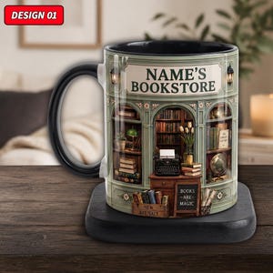 Op de afbeelding: Een zwarte keramische mok met een bedrukte illustratie van een boekenwinkel, boekenplanken, een typemachine en het opschrift NAME'S BOOKSTORE. Een klein krijtbordje in het ontwerp toont de tekst BOOKS ARE MAGIC.