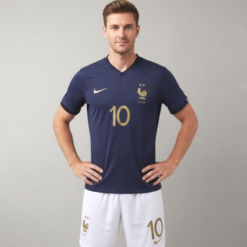Pode incluir: Camisola de futebol azul marinho com detalhes dourados, com o n&uacute;mero 10 e um emblema de galo. A camisola tem decote em V e mangas curtas. Cal&ccedil;&otilde;es brancos com o n&uacute;mero 10 completam o conjunto.