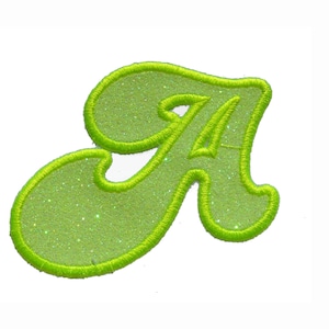 Peut inclure: Une lettre A en feutre vert lime avec une finition pailletée. La lettre est soulignée d'un fil vert vif.
