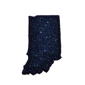 May include: A blue glitter patch in the shape of the state of Indiana. The patch has a dark blue outline and is covered in blue glitter.