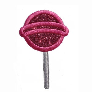 May include: A pink glitter lollipop with a silver stick. The lollipop is round and has a white stripe around the middle.