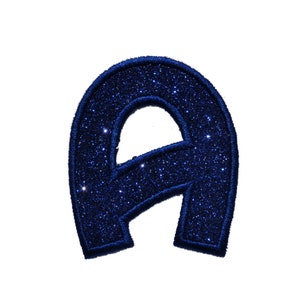 Könnte beinhalten: Ein blauer Glitzerbuchstabe A. Der Buchstabe ist aus Filz und hat eine glitzernde Oberfläche.