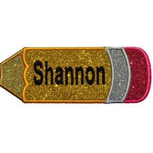 Könnte beinhalten: Ein goldener Glitzer-Bleistift mit einem schwarzen Radiergummi und einem roten und silbernen Glitzerband. Der Name "Shannon" ist in Schwarz auf den Bleistift geschrieben.