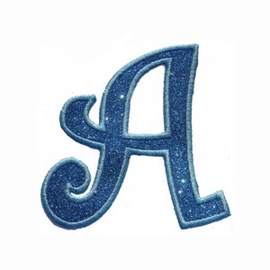 May include: A blue glitter iron-on patch in the shape of the letter A. The letter is in a cursive font.
