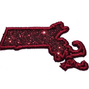 May include: A red glitter iron-on patch in the shape of the state of Massachusetts.