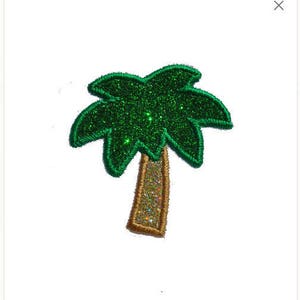 May include: A green glitter palm tree with a gold glitter trunk. The palm tree is a patch for sewing or ironing onto fabric.