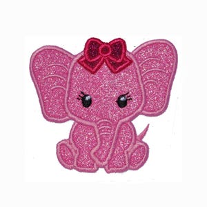 May include: A glittery pink elephant patch featuring a dark pink bow on its head. The elephant has large ears, black eyes with long eyelashes, and a trunk curled to the side. The entire design is outlined with a stitched border on a white background.