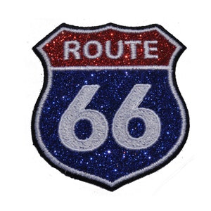 May include: A Route 66 patch in a shield shape, featuring a red glitter top section with the word "ROUTE" and a blue glitter bottom section with the number "66" in white. The patch has a black border.