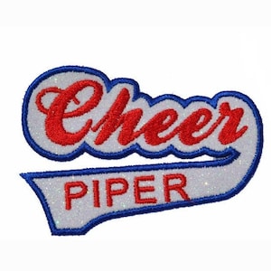 Op de afbeelding: Wit, blauw en rood geborduurd patch met het woord "Cheer" in rood en het woord "Piper" in wit.