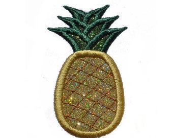 Może przedstawiać: Złoty ananas z brokatem i zielonymi liśćmi. Ananas jest wyszyty złotą nicią.