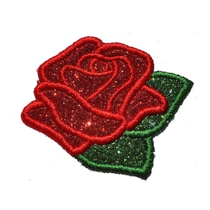 May include: A red glitter rose with green glitter leaves. The rose is embroidered and has a 3D effect.
