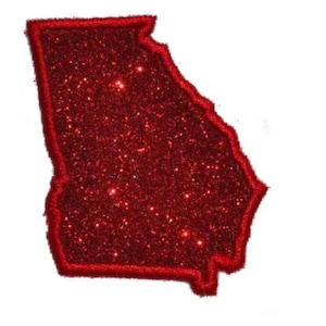 May include: A red glitter patch shaped like the state of Georgia. The patch features a dense, sparkling red surface texture with a solid red stitched border outlining the entire perimeter of the state shape against a plain white background.