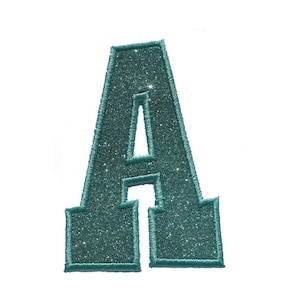 Könnte beinhalten: Ein aufbügelbarer Patch in Form des Buchstabens A aus glitzerndem Türkis. Der Buchstabe ist mit dunkelblauem Garn umrandet.