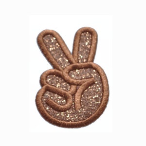 Op de afbeelding: Een bruine glitter peace-teken patch. De patch is gemaakt van vilt en heeft een glinsterende afwerking.
