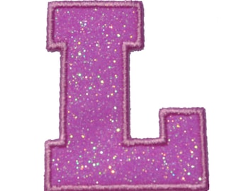 May include: A pink glitter iron-on patch in the shape of the letter L. The patch has a white outline.