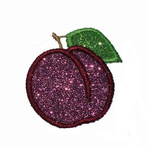 May include: A glittery purple peach-shaped embroidered patch with a dark red stitched border. The fruit features a textured, sparkling surface and is topped with a single, bright green glittery leaf attached by a small brown stem.