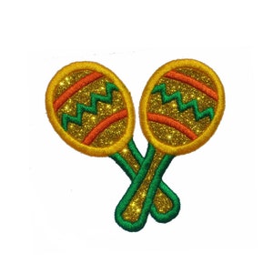 May include: A pair of maracas with gold glitter and green handles. The maracas have orange and red stripes.