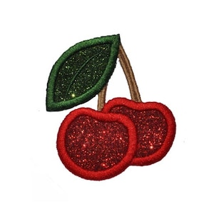 Puede incluir: Dos cerezas rojas con hojas verdes y detalles de purpurina.