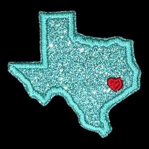 Pu&ograve; includere: Un contorno di glitter turchese dello stato del Texas con un cuore rosso al centro.