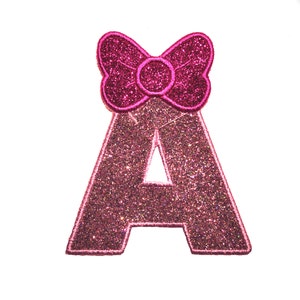 May include: Pink glitter letter A with a pink glitter bow on top.