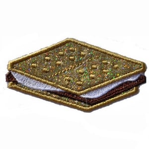 Pode incluir: Patch bordado em forma de s'more. O patch apresenta um biscoito Graham dourado brilhante, marshmallow branco e uma camada de chocolate marrom escuro. As bordas são delineadas em dourado.