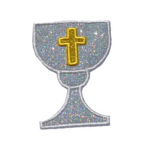 May include: A silver glitter iron-on patch of a chalice with a gold cross inside.