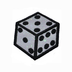 Peut inclure: Un dé en paillettes argentées avec des points noirs et un contour noir. Le dé est un patch brodé en 3D.