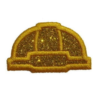 May include: A gold glitter hard hat patch. The patch is embroidered with a gold thread and has a shiny, sparkly finish.