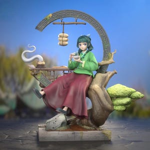 May include: A detailed figurine of a person in traditional attire, seated on a stylized tree branch. The figure wears a green top and burgundy skirt, holding a bowl. A decorative arch and food items are also present, with a serene, blue background.
