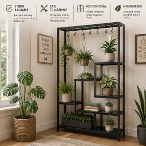 May include: A black metal shelving unit with an open frame design, featuring multiple staggered shelves and a top bar with hanging hooks. The unit holds various potted plants, including ferns and a peace lily, along with stacked books.