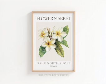 May include: A framed vertical wall art print featuring a botanical illustration of white and yellow plumeria flowers with green leaves. The text FLOWER MARKET appears at the top, with OAHU NORTH SHORE and Plumeria printed at the bottom.