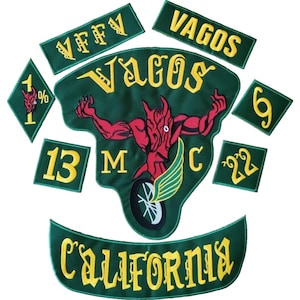 Puede incluir: Un conjunto de parches bordados en verde y amarillo. El parche central presenta una figura de diablo rojo con las palabras "Vagos MC" y una rueda de motocicleta alada. Parches adicionales incluyen las palabras "Vagos", "California" y otros números y símbolos.