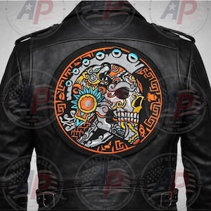 May include: A black leather jacket featuring a large, circular embroidered patch on the back. The patch displays a detailed, multi-colored skull design with intricate orange, blue, and silver patterns, surrounded by a thick orange circular border.